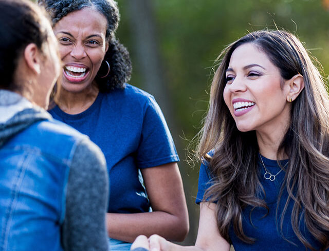 three women talking and shaking hands