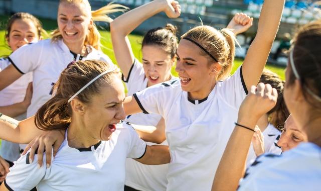 girls athletic team jumping up and down in celebration