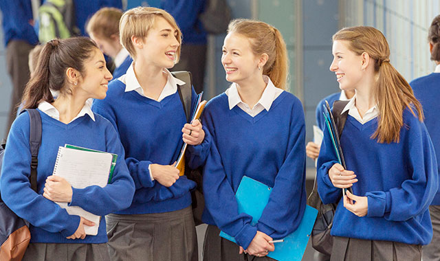 Four Girls Standing in Hallway at School Laughing