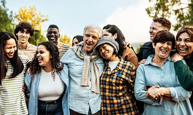 large group on young and older adults hugging and smiling